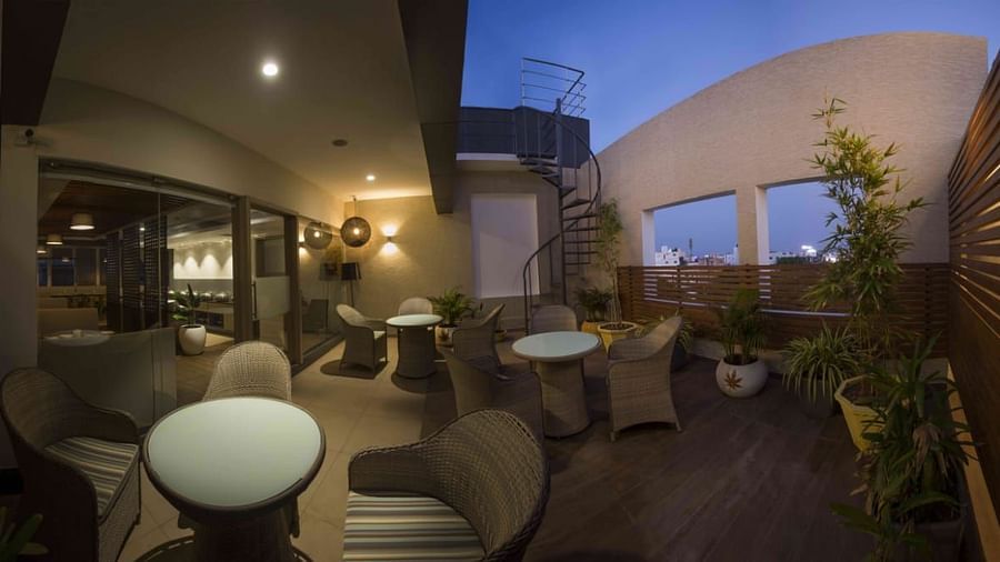 Mint N Mustard Rooftop Restaurant at Mayberry Tiruppur with an open roof with plants and a relaxed dining atmosphere